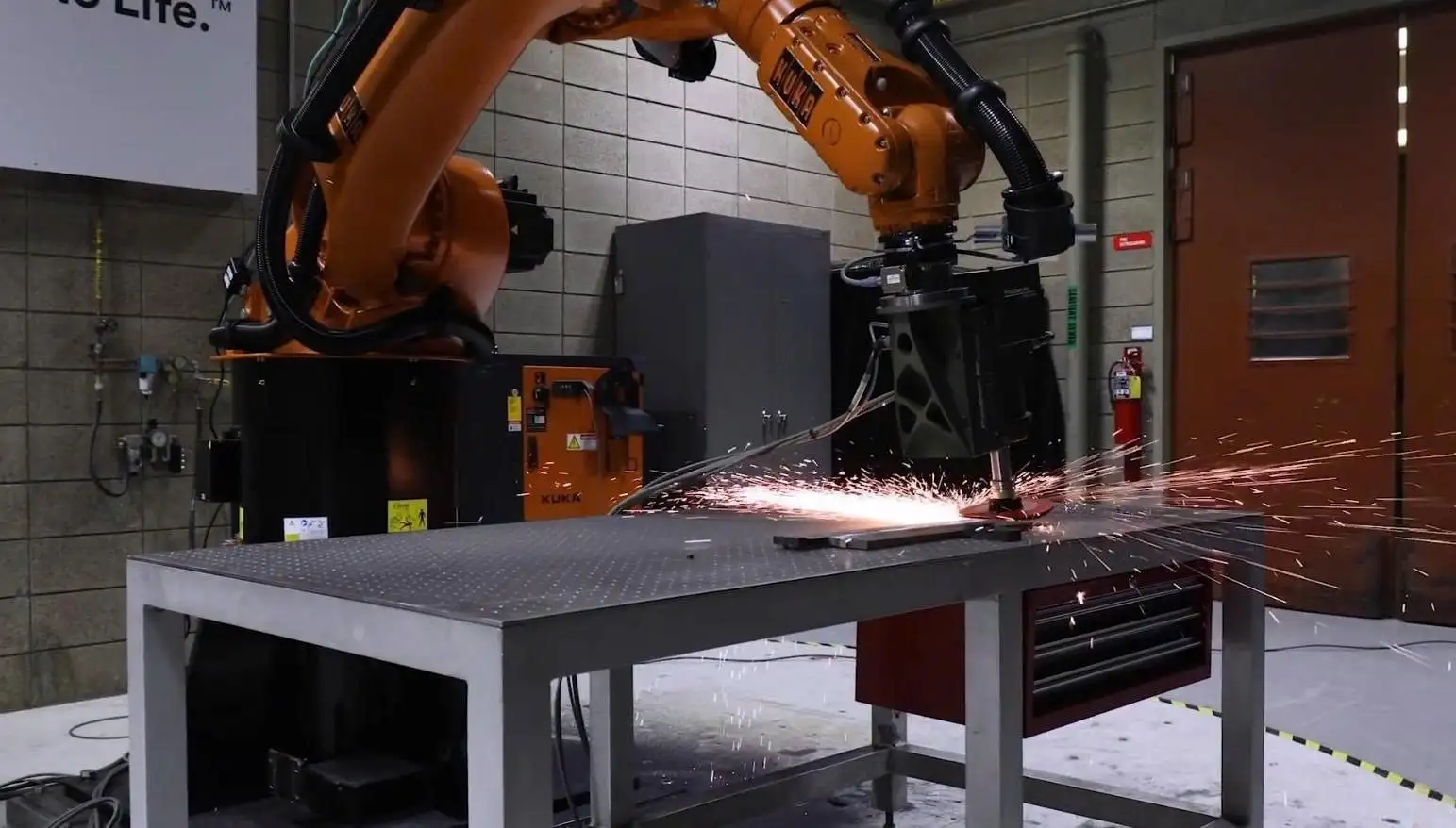 Cánh tay robot công nghiệp KUKA thực hiện mài nhẵn kim loại tự động, đảm bảo độ chính xác và an toàn cao