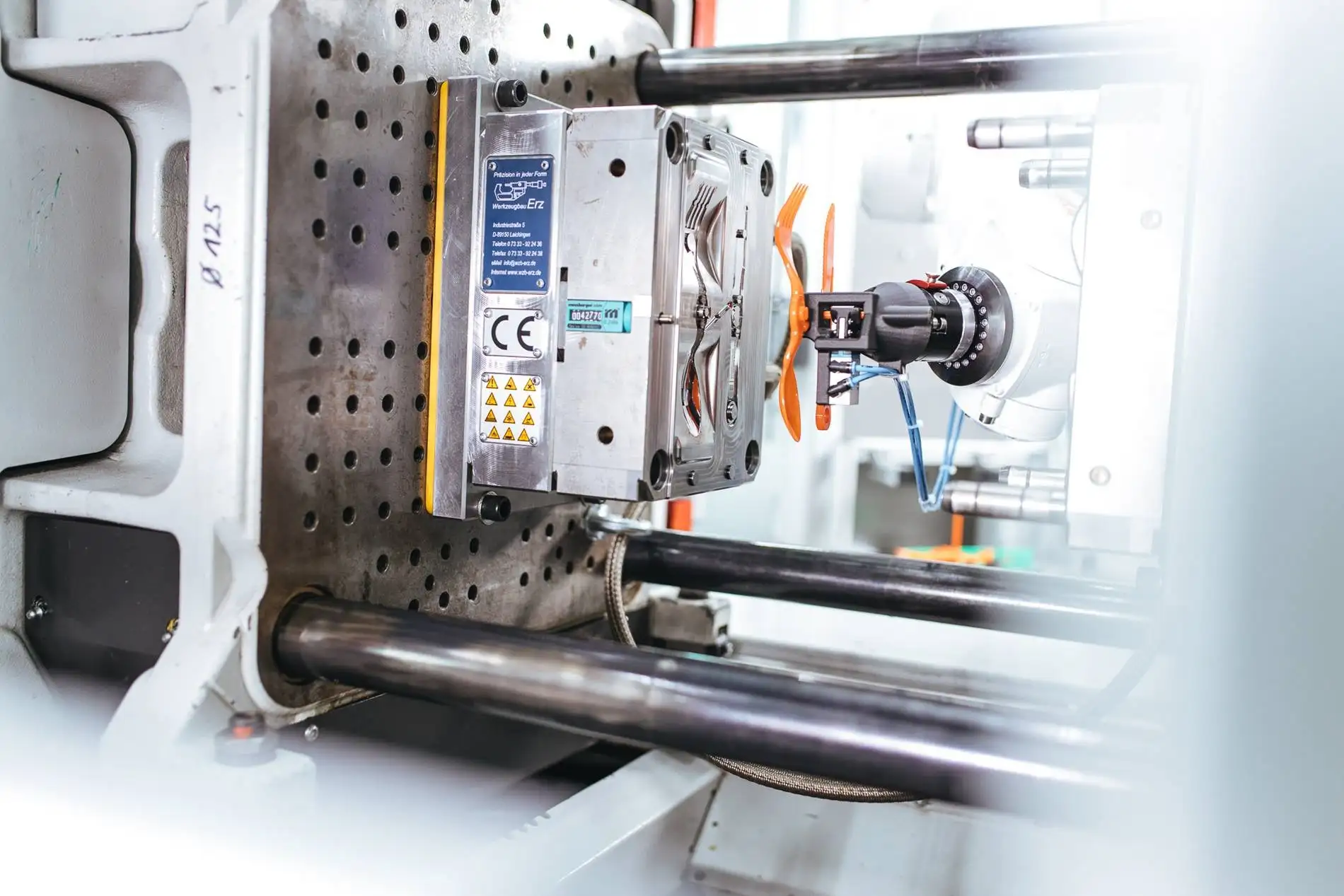 Cánh tay robot công nghiệp tự động lấy sản phẩm nhựa thành phẩm ra khỏi khuôn đúc trong một máy ép nhựa hiện đại