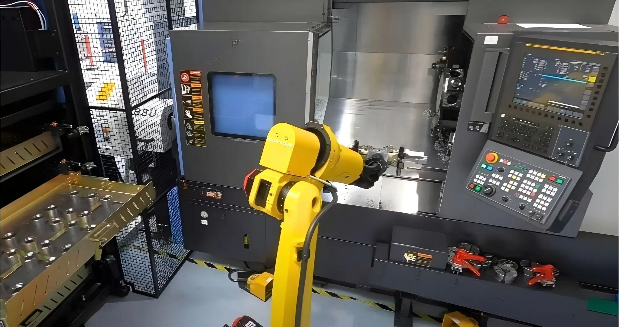 Cánh tay robot vừa lấy phôi hoàn thiện ra khỏi máy CNC sau quá trình gia công