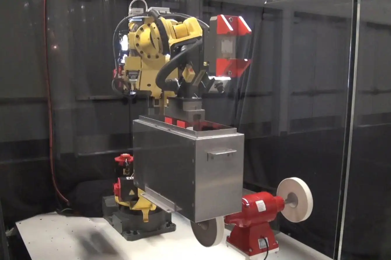 Robot đánh bóng đang thực hiện xử lý bề mặt chi tiết kim loại
