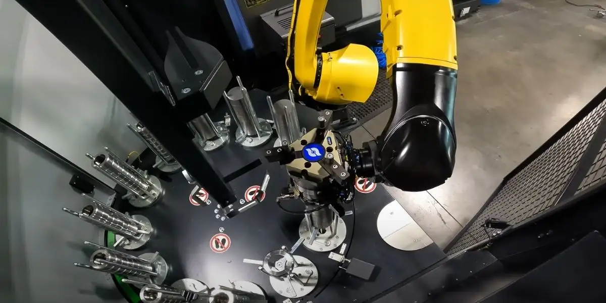 Cánh tay robot gắp phôi từ bàn gá phôi nạp vào máy CNC