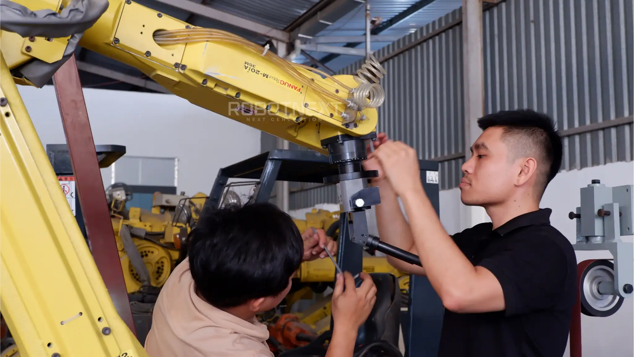 Giải pháp cho hệ robot cấp phôi máy CNC toàn diện - Tự động hóa cùng Robotnext 3 Kỹ sư ROBOTNEXT hiệu chỉnh và lắp đặt bộ kẹp phôi trên cánh tay robot công nghiệp FANUC trước khi tích hợp vào dây chuyền CNC