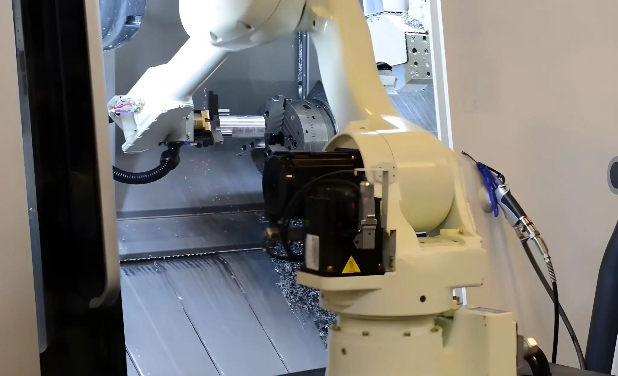 Robot lấy sản phẩm ra khỏi máy CNC sau khi gia công